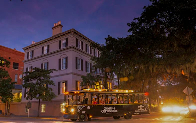 St. Augustine Ghosts & Gravestones tour trolley at dusk near historic building.