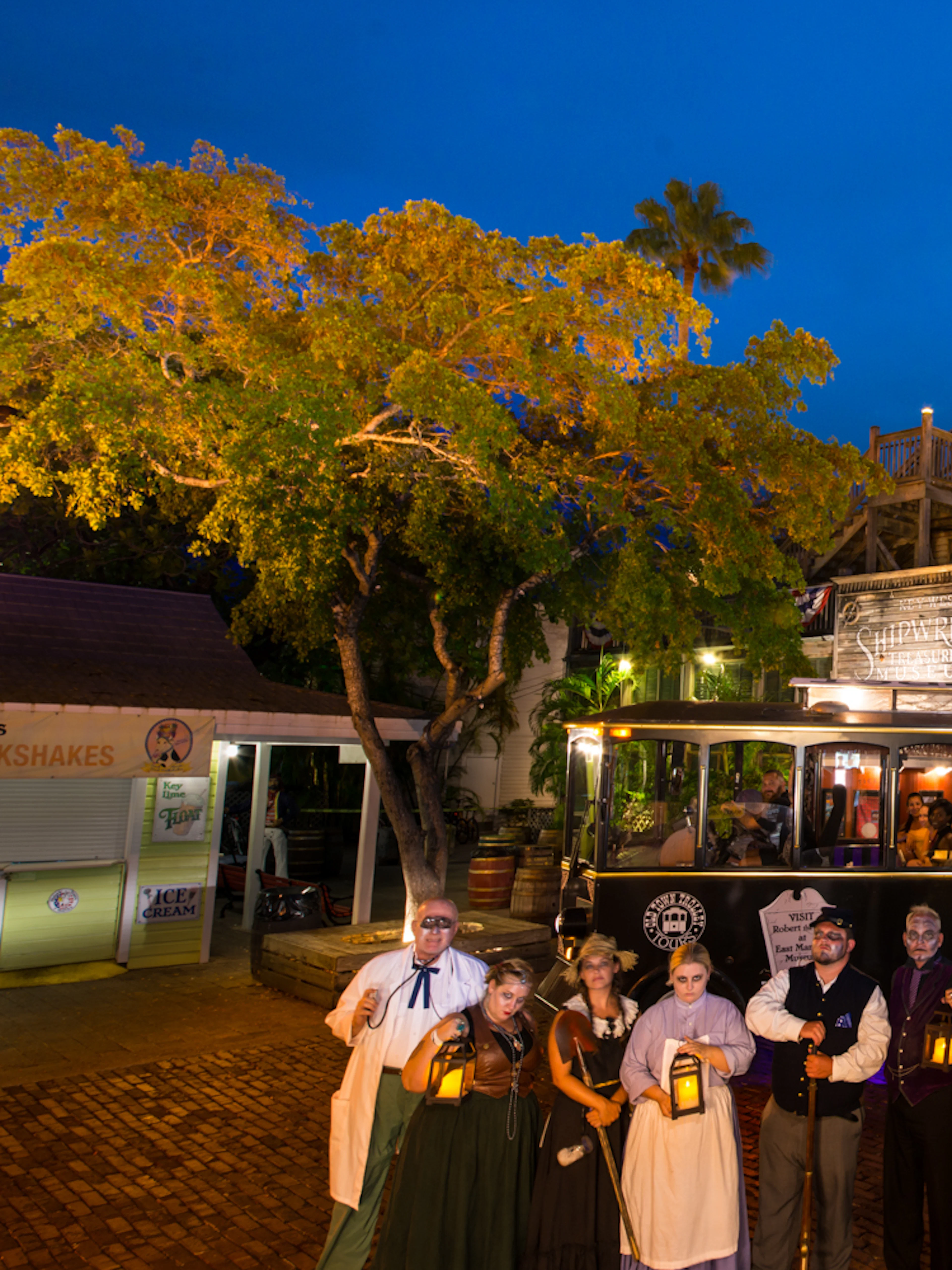 St. Augustine Ghosts & Gravestones tour trolley with guides in period costumes at night.