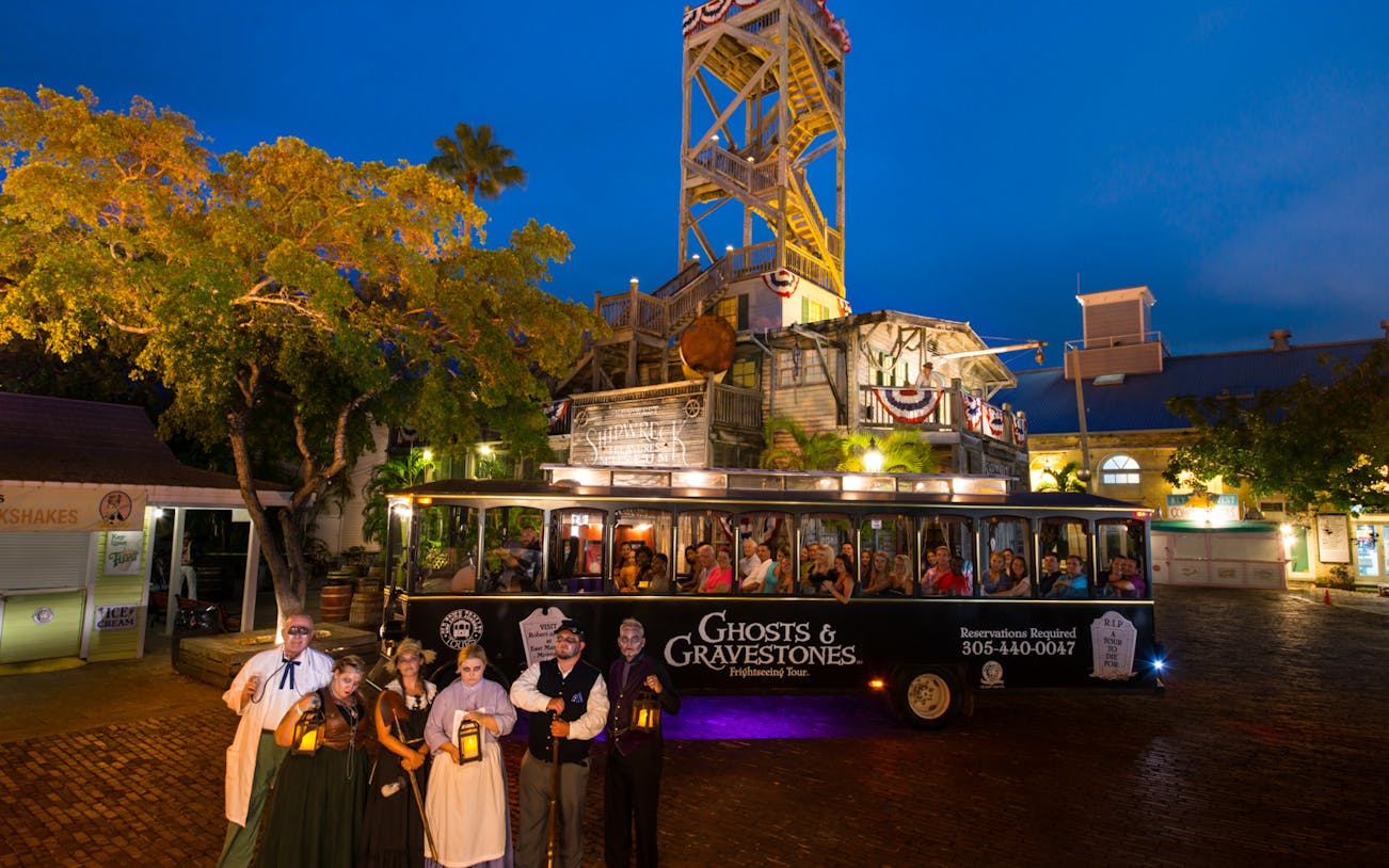 St. Augustine Ghosts & Gravestones tour trolley with guides in period costumes at night.