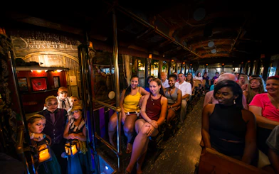 Tourists on St. Augustine Ghosts & Gravestones trolley with costumed guides.