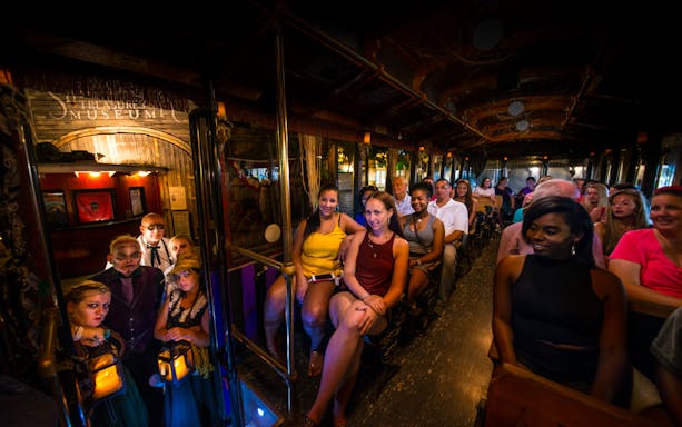 Tourists on St. Augustine Ghosts & Gravestones trolley with costumed guides.