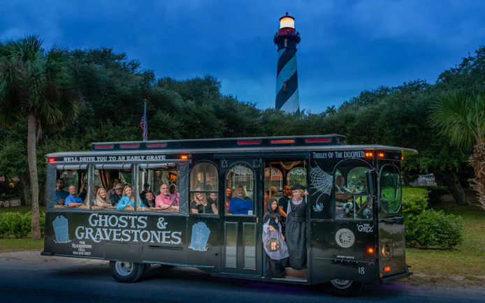 Trolley tour for St. Augustine Ghosts & Gravestones with lighthouse in background.