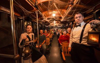St. Augustine ghost tour participants on a trolley with guides holding lanterns.