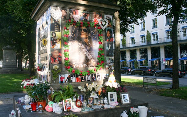 Memorial for a famous musician in Munich with flowers and photos during an evening walk.