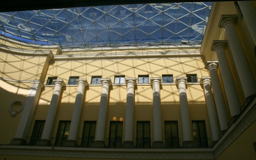Munich building interior with glass ceiling and columns during evening walk.