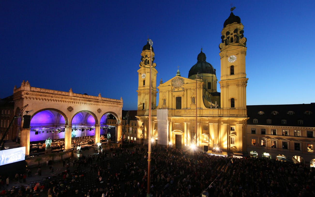 Munich's Odeonsplatz at dusk with illuminated Theatinerkirche and Feldherrnhalle.