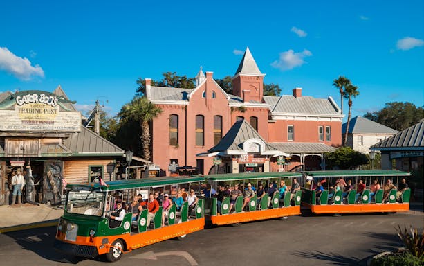 St. Augustine Old Town Trolley passing historic buildings and Gator Bob's Trading Post.