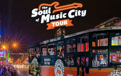 Nashville night tour bus with passengers on a city street, neon lights in the background.