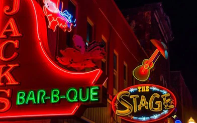 Neon signs of Jack's Bar-B-Que and The Stage on Broadway, Nashville at night.