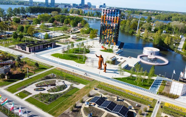 Aerial view of Floriade Expo 2022 in Almere with colorful building and landscaped gardens.