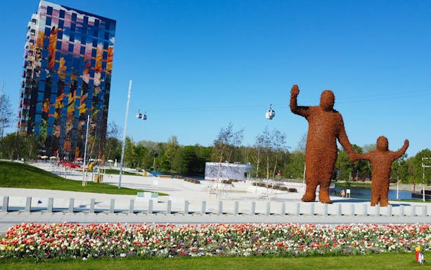 Sculptures and colorful building at Floriade Expo 2022 in Almere with cable cars above.