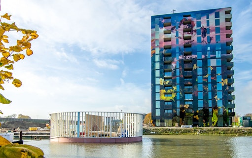 Almere Floriade Expo 2022 building with colorful facade by the water.