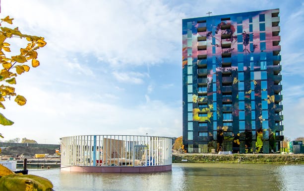 Almere Floriade Expo 2022 building with colorful facade by the water.