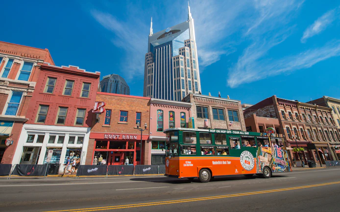 Nashville Old Town Trolley passing historic buildings with AT&T Building in background.