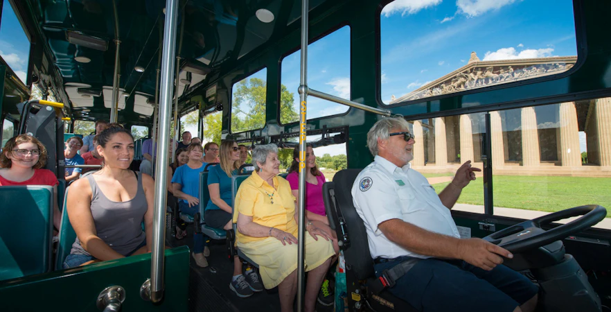 Passengers on Nashville hop-on hop-off trolley tour passing the Parthenon replica.