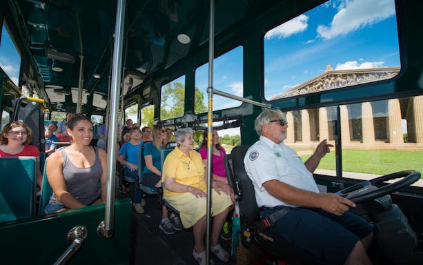 Passengers on Nashville hop-on hop-off trolley tour passing the Parthenon replica.
