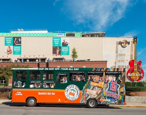 Nashville Old Town Trolley in front of Hard Rock Cafe with passengers on board.