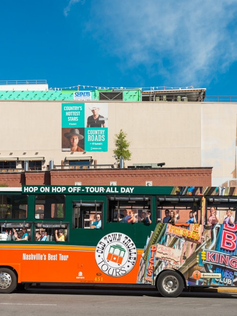 Nashville Old Town Trolley in front of Hard Rock Cafe with passengers on board.