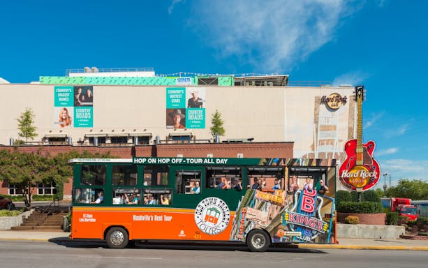 Nashville Old Town Trolley in front of Hard Rock Cafe with passengers on board.