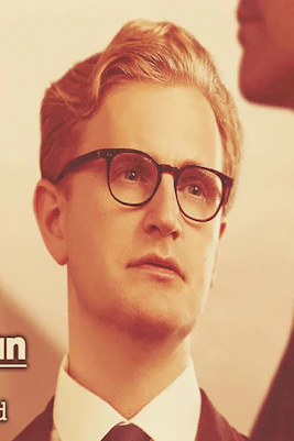 Man in glasses looking at another person, text reads "A Single Man" based on Christopher Isherwood's book.