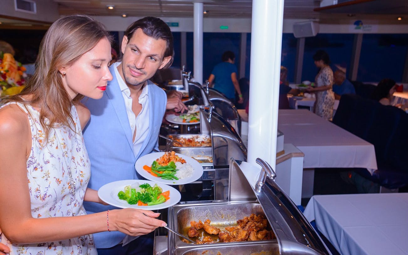 Couple enjoying buffet dinner on Bali sunset cruise.