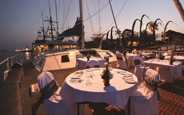 Dinner setup on a yacht deck during a Bali sunset cruise.
