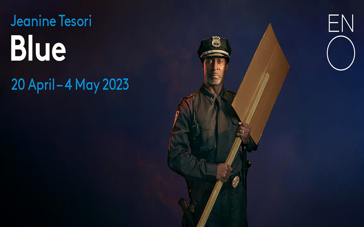 Police officer holding a cardboard sign for the opera "Blue" by Jeanine Tesori, ENO, April-May 2023.