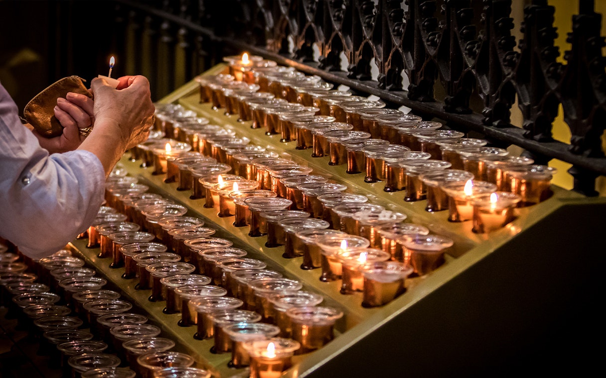 Lighting candles inside Milan Duomo during Skip-the-Line tour.