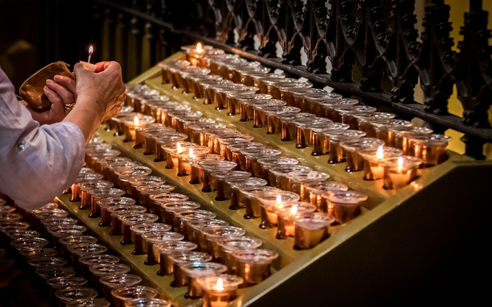 Lighting candles inside Milan Duomo during Skip-the-Line tour.