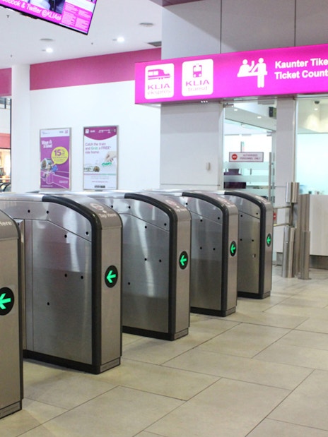 KLIA Ekspress ticket counter and turnstiles at Kuala Lumpur station.
