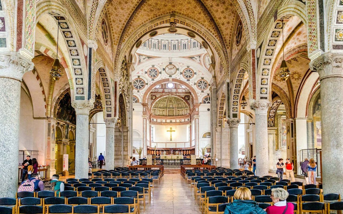 Interior of Santa Maria delle Grazie, Milan, showing ornate arches and central altar.