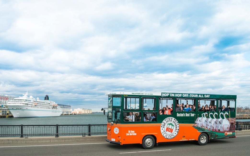 Boston Old Town Trolley passing by a docked cruise ship.