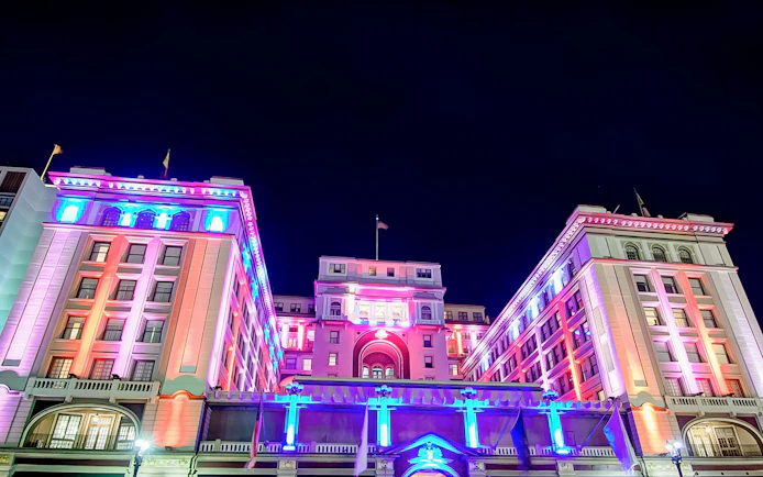 Historic San Diego building illuminated with colorful lights at night.