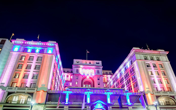 Historic San Diego building illuminated with colorful lights at night.