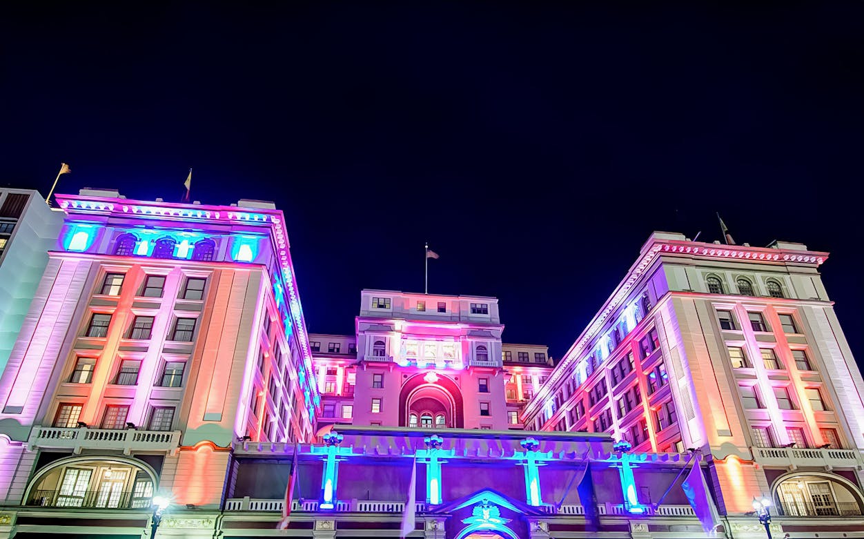 Historic San Diego building illuminated with colorful lights at night.