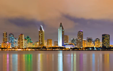 San Diego skyline illuminated at night, viewed from across the water.