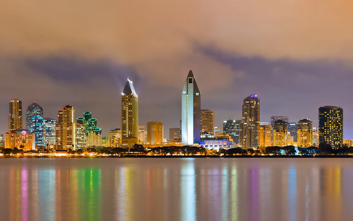 San Diego skyline illuminated at night, viewed from across the water.