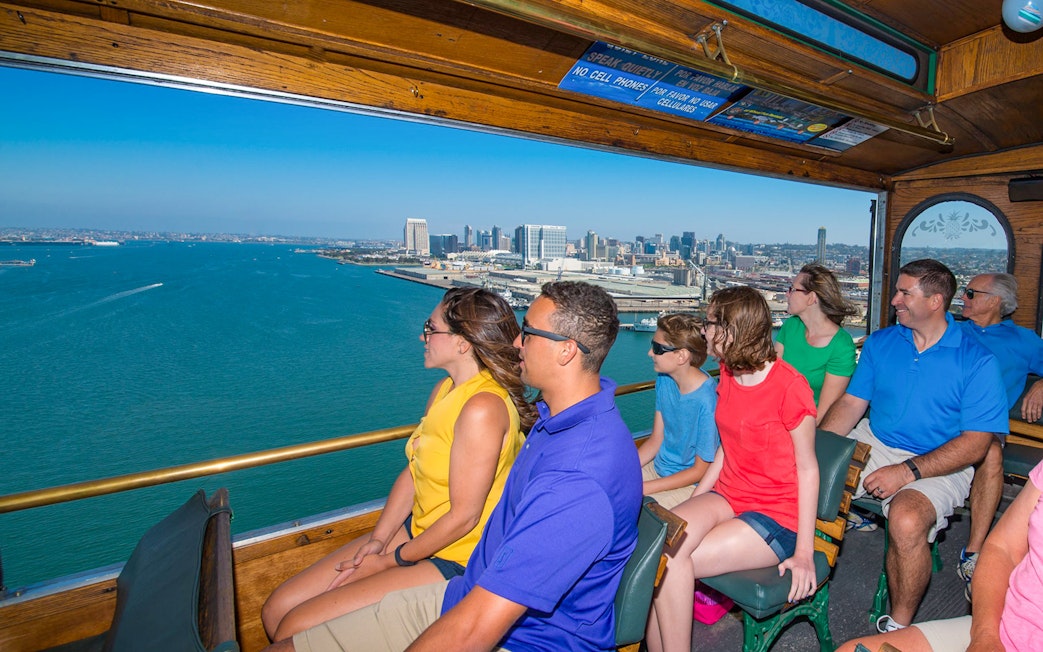 Tourists enjoying a scenic view of the San Diego skyline from an Old Town trolley.