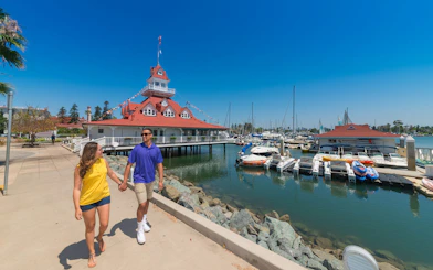 Couple walking near marina and historic building on Old Town Trolley Tour.