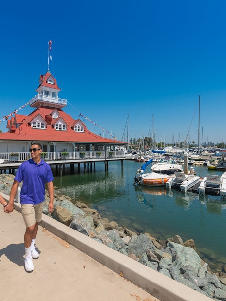 Couple walking near marina and historic building on Old Town Trolley Tour.