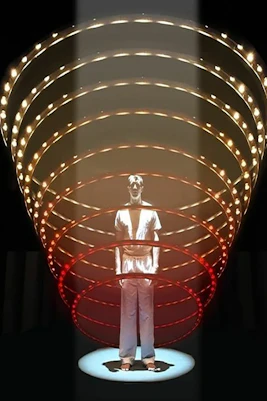 Man standing under illuminated spiral structure, related to "9 Circles" by Bill Cain.