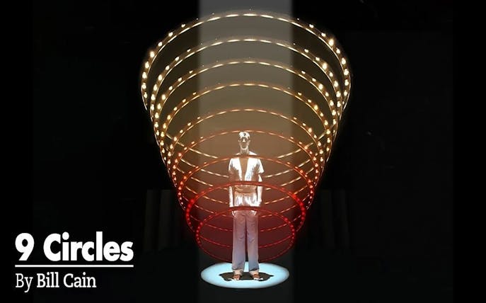 Man standing under illuminated spiral structure, related to "9 Circles" by Bill Cain.