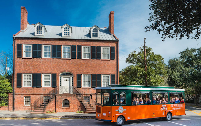 Savannah Old Town Trolley passing historic brick building.