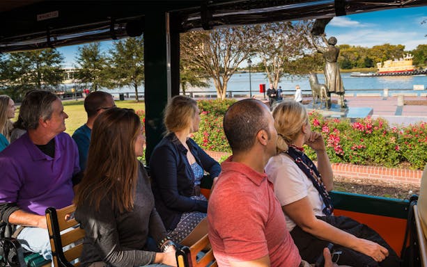 Tourists on Savannah Old Town Trolley viewing the Waving Girl statue by the river.