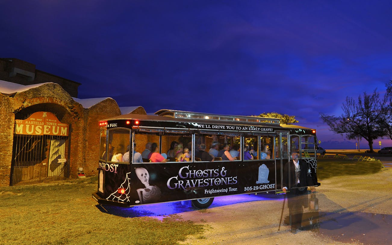 Ghosts & Gravestones tour trolley at night near East Martello Museum.