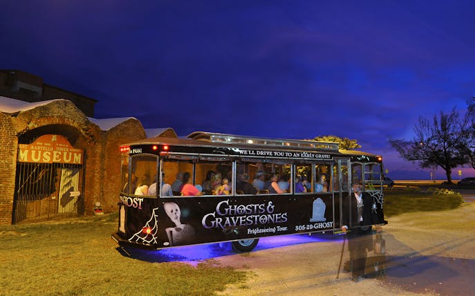 Ghosts & Gravestones tour trolley at night near East Martello Museum.