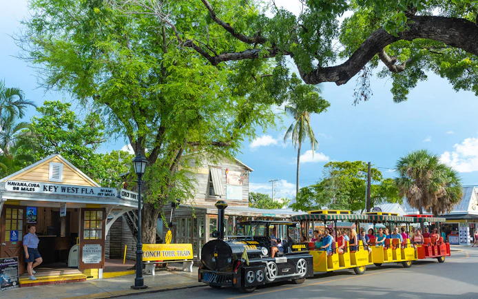 Guided Conch Tour Train passing historic buildings in Key West, Florida.