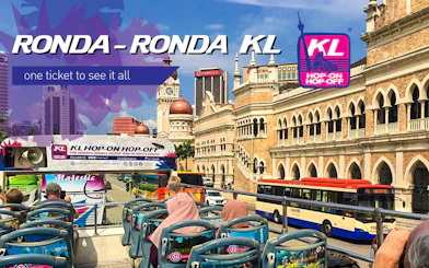 KL Hop-on Hop-off bus passing Sultan Abdul Samad Building in Kuala Lumpur.