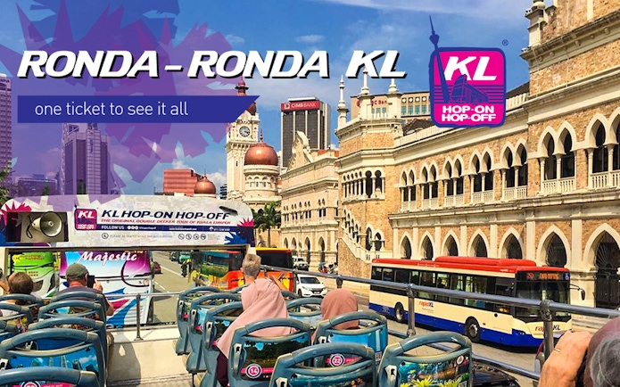 KL Hop-on Hop-off bus passing Sultan Abdul Samad Building in Kuala Lumpur.