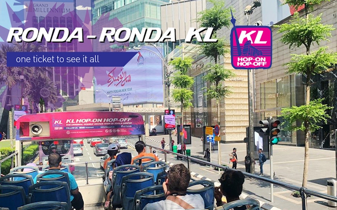 Open-top bus on Kuala Lumpur street for Hop On Hop Off tour near Sunway Lagoon.